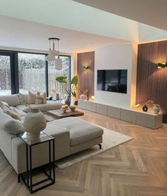 a modern living room with wood flooring and large windows