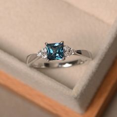 a blue diamond ring sitting in a box