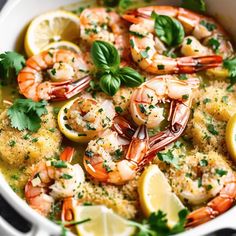 a bowl filled with shrimp, lemons and parsley