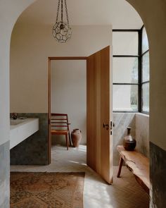 an archway leading into a bathroom with a wooden bench