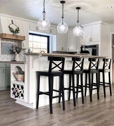 a kitchen island with four stools in front of it and an open floor plan