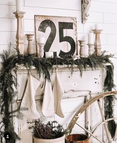 a mantel with stockings and candles on it, next to an old wagon wheel