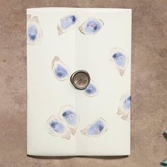 a button is sitting on top of a piece of paper with blue and white designs