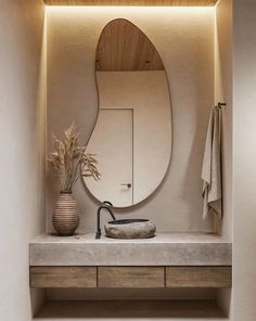 a bathroom with a sink, mirror and plants on the counter in front of it