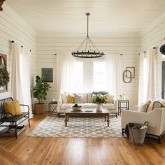 a living room with white walls and wood floors