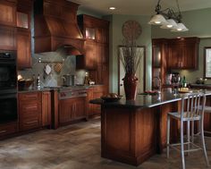 a kitchen with green walls and wooden cabinets is pictured in this image, there are four stools at the center of the island