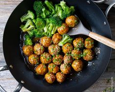 broccoli and meatballs are being cooked in a skillet