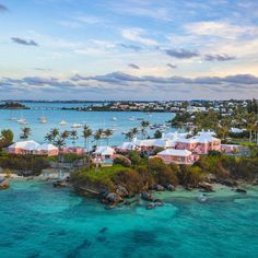 an aerial view of the ocean with boats in the water and houses on land next to it