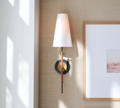 a lamp is on the wall next to a picture