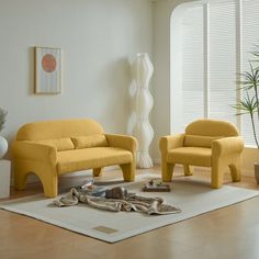 a living room with two yellow chairs and a white rug