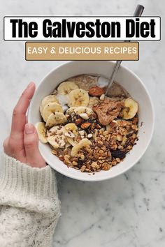 a person holding a bowl of cereal with bananas and nuts in it, on top of a marble countertop