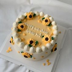 a birthday cake decorated with sunflowers and white frosting