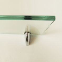 a glass shelf with a metal hook on it