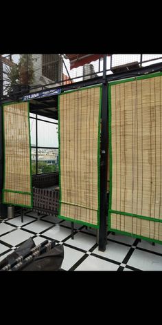 three bamboo screens are hanging on the side of a building with black and white checkered flooring