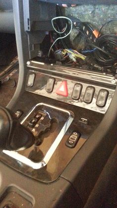 the inside of a car with an electronic device in it's center console and wires on the dash board