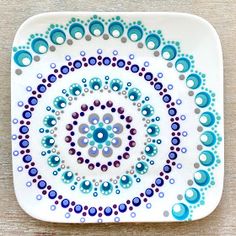 a white plate with blue and purple designs on the rim, sitting on a wooden surface