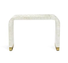 a white marble and brass console table with an intricate design on the top, against a white background