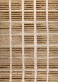 a beige rug with squares and lines on the bottom, in various shades of brown