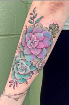 a woman's arm with a colorful flower tattoo on the left side of her arm