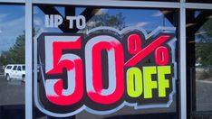 a window with a sign that says up to 50 % off