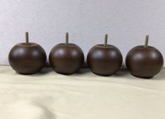 four brown apples sitting on top of a table