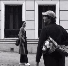 black and white photograph of two people walking down the street