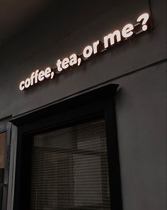 a sign that says coffee, tea, or me on the side of a building