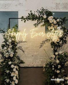 two white flowers and greenery in front of a sign that says, may always you