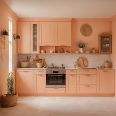 a kitchen with peach colored cabinets and white counter tops