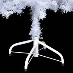 a white christmas tree on top of a chair with no legs and one leg up