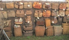 many baskets and bags are arranged on the wall