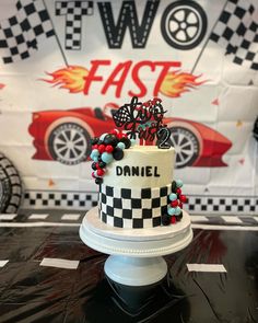 a cake decorated with cars and beads on a table in front of a fast food sign