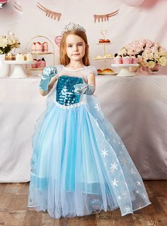 Elsa from Frozen is the favorite Disney princess of many little girls and being able to wear her charming dress is the dream of many young hearts. This Frozen costume is a direct copy of Elsaiconic dress in the movie. Let your girl wear this dress and make her feel like a real-life princess. The blue dress has a see-through scoop neckline with short see through puff sleeves. The bodice of the dress is decorated with an abundance of blue sequins that give it the characteristic Frozen look. a tulle shawl flows from the shoulders of the dress and extends to the floor acting as Elsafamous cape. Frozen Princess Dress, Tulle Shawl, Sequin Flower Girl Dress, Favorite Disney Princess, Elsa From Frozen, Frozen Elsa Dress, Long Flower Girl Dresses, Frozen Costume, Blue Ball Gowns