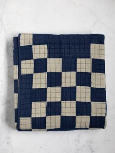 a blue and white checkered blanket sitting on top of a marble countertopstone