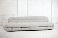 a white couch sitting in front of a brick wall