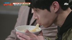 a young man is eating from a bowl