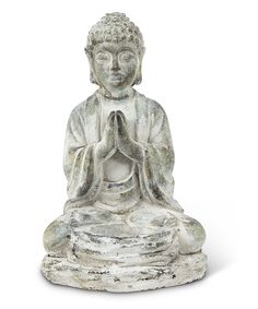 a buddha statue sitting on top of a white surface