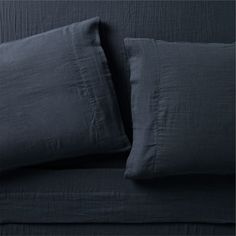 an image of a bed with dark blue linens