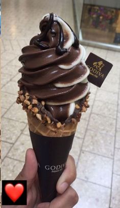 an ice cream sundae with chocolate icing and nuts on top in a store