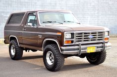 a brown pick up truck parked in front of a building