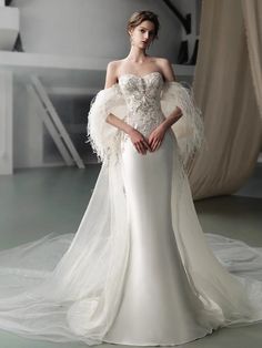 a woman in a wedding dress with feathers on it