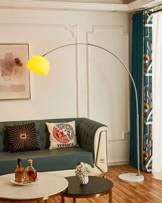 a living room with a couch, coffee table and floor lamp in it's corner