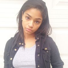 a woman with freckled hair is standing in front of a white garage door