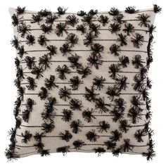 an embroidered pillow with black flowers on it