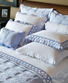 a bed with blue and white pillows on it