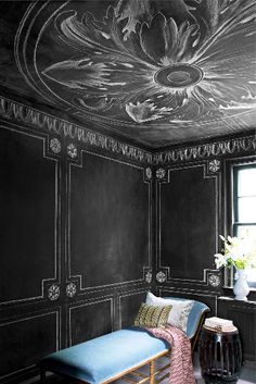 a room with black walls and painted ceilings