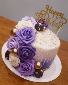 a birthday cake decorated with purple and white flowers