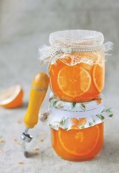 a jar filled with oranges sitting on top of a table next to an orange peel