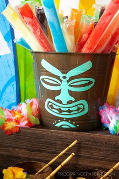 a bucket filled with colorful candy sticks next to some chopsticks on a table