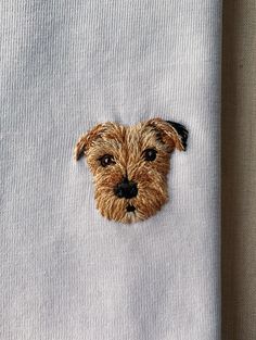 a dog's face is embroidered onto a white shirt